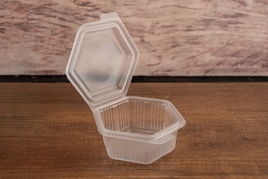 Detailed view of the Packmaster CF11 500 cc hexagonal container with open lid, highlighting the tamper-evident safety lock mechanism.