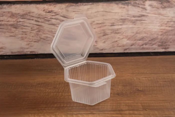 Packmaster CF12 1200 cc sızdırmaz dikdörtgen kabın açık kapak görünümü ve tamper-evident emniyet kilidi mekanizması detayı.